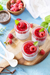 Chia seed pudding with raspberry and jam or smoothies with chia seeds on a stone table. Healthy breakfast. Copy space.