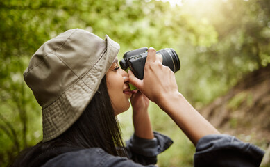Fototapeta premium Thats a great photo. Cropped shot of an attractive young woman taking photographs while hiking in the wilderness.