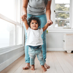 Shes growing too fast. Shot of a little girl learning to walk with the help of her mother.