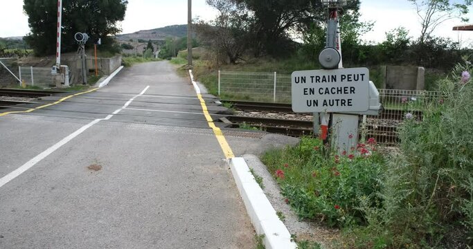 French Level Crossing with Warning Sign Un Train Peut En Cacher Un Autre near Montpellier