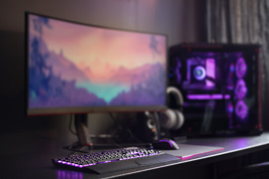 Modern gaming desktop setup, RGB lights, widescreen monitor and water cooling. Purple background