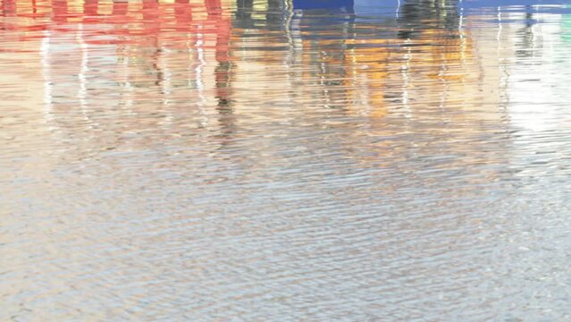 ripples on water with reflections of houses