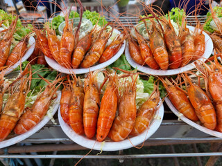 large steamed river prawns arranged neatly and beautifully on a white plate Served with sweet seafood sauce Sour and spicy. To prepare to sell to customers in the market.