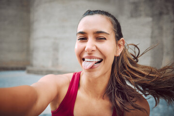 Finding the fun in fitness. Cropped portrait of an attractive young female athlete taking selfies...