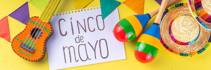 Mexican Cinco de Mayo holiday background with mexican cactus,guitars, sombrero hat, maracas, Bright yellow flat lay with traditional Cinco de Mayo decor and party accessories
