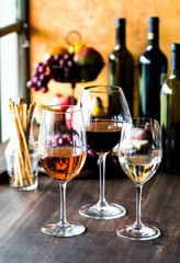 long stem wine glasses containing red, white and rose wine. 