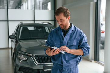 Man in blue uniform is working in the car service