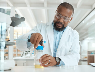 Lets see whats causing the infection. Shot of a handsome mature scientist sitting alone in his laboratory and opening a bottle of liquid for testing.