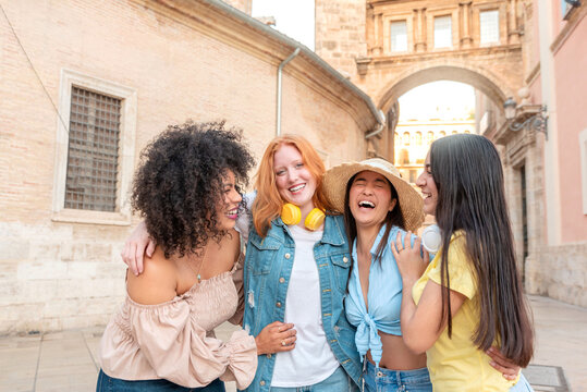 Cheerful diverse women standing and having fun on street