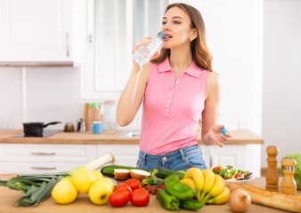 Attractive woman drinking water in the kitchen before breakfast