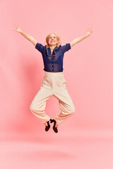 Portrait with one attractive woman jumping with spreaded hands over pink studio background. Good news, perfect event