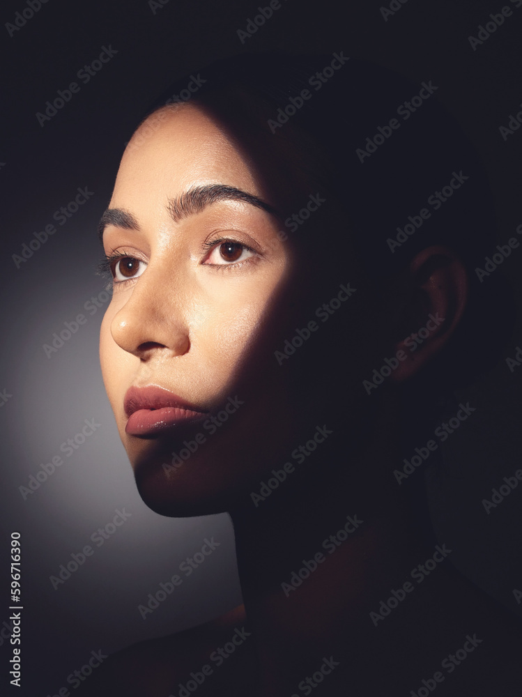 Canvas Prints Theyre always looking for imperfections.... Studio shot of a beautiful young woman posing with light beam against her face.