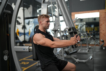 Fototapeta na wymiar Man doing weight lifting exercises inside the gym