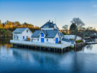 White and blue houses on a small rocky island in Rimmeflui, Alversund, Norway
