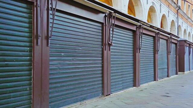 Line of small shops closed with black shutters in Venice
