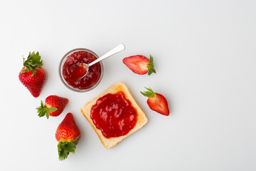 A top view of the strawberry jam-filled bread and strawberry fruit isolated on white