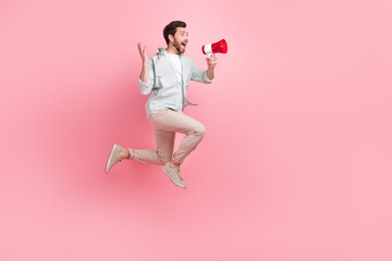 Full length photo of funky impressed man wear turquoise shirt shouting toa empty space jumping high...