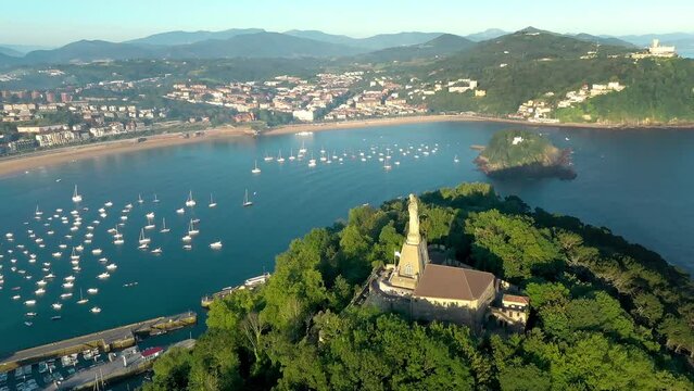 City of San Sebastian, in Vesque Country, perspective from above. View of the statue of "Sagrado Coraz&oacute;n de Jes&uacute;s" - above Motako Gaztelua Castle. Drone rotating left around the statue