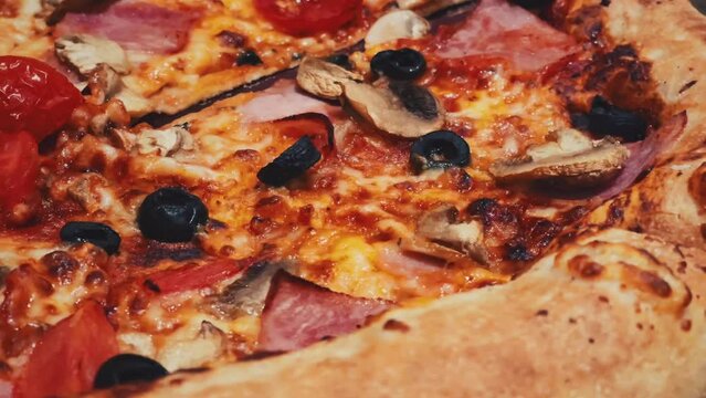 Close-up video of pizza capriciosa in a pizzeria.