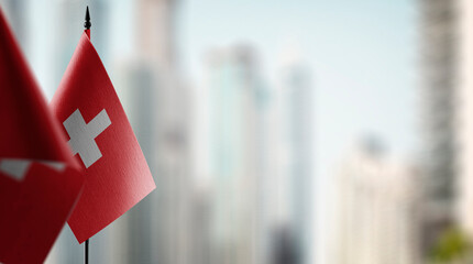 Small flags of the Switzerland on an abstract blurry background