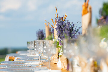 Beautiful outdoor celebration table green background with lavender decoration