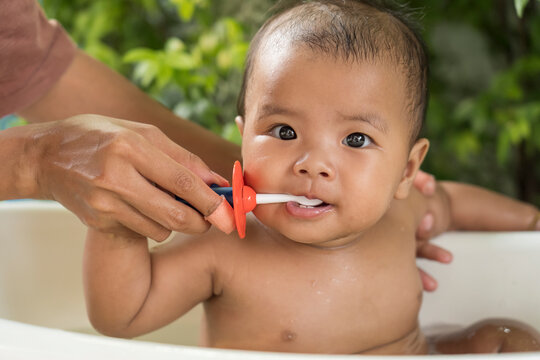 happy Asian Infant to brush teeth with mom. health care and cleaning teeth concept