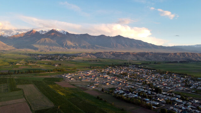 Aerial panorama of the town of Kochkor, Kyrgyzstan and surrounding fields and mountains.