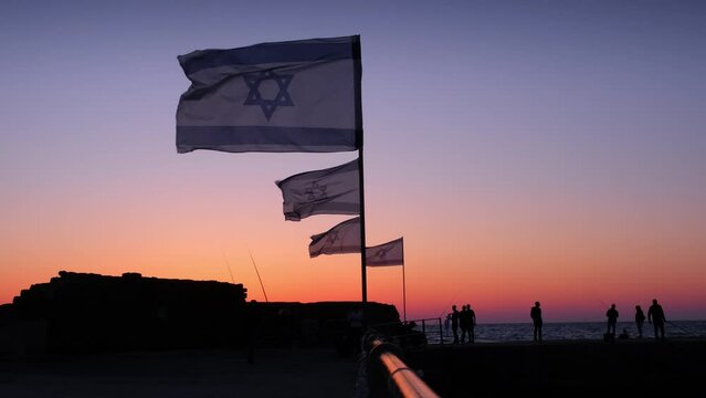 Israeli coast of the Mediterranean Sea and Israeli flags on the shore of the pier where the fishermen fish. High quality 4k footage
