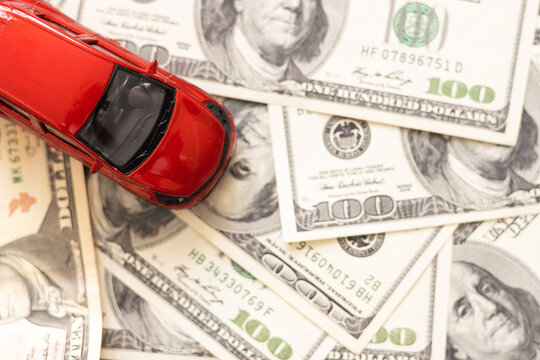 Toy car, money, documents. The concept of buying and insuring cars. Car, money