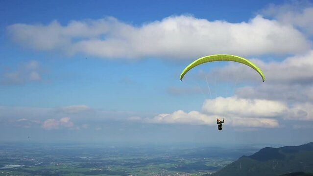 Paraglider flies from Mount on an paraglider over beautiful landscape with lakes