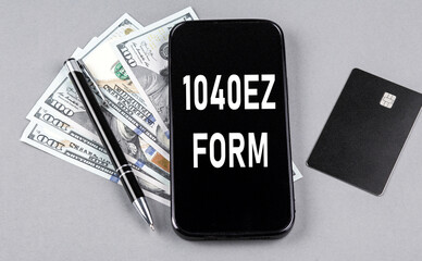 Credit card and text 1040 EZ FORM on smartphone with dollars and pen. Business concept