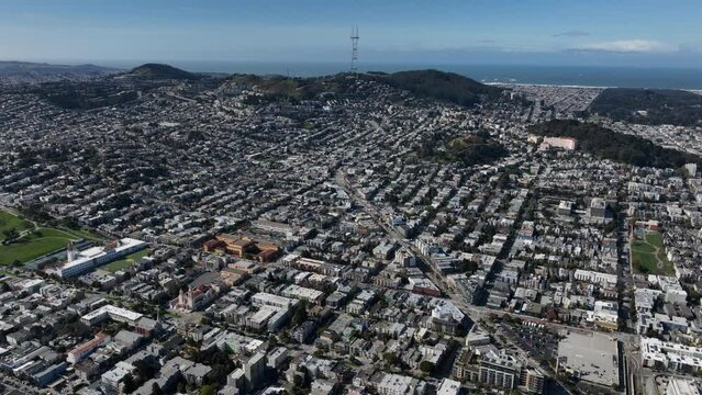 Aerial panoramic footage of streets and buildings in metropolis. Rising hills and Twin Peaks with Sutro telecommunication tower.