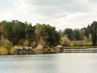 Lac de la Cassière dans le Puy-de-Dôme parsemé d'énormes bloc de roches volcaniques avec vue...