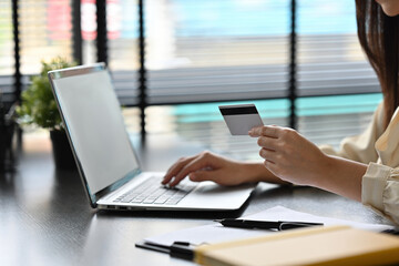 Close up image of Business woman using credit card and laptop computer.