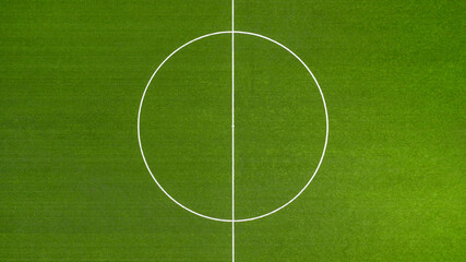 Obraz premium Aerial closeup of the midfield circle in an empty synthetic grass football field. Here the kick off is taken in a game of soccer.