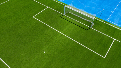 Aerial closeup of the penalty spot on an empty synthetic grass soccer field. Here a penalty is taken in a soccer game.