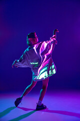 Portrait of dreaming girl, woman dancing with emotion with inscription of neon glow on body over...