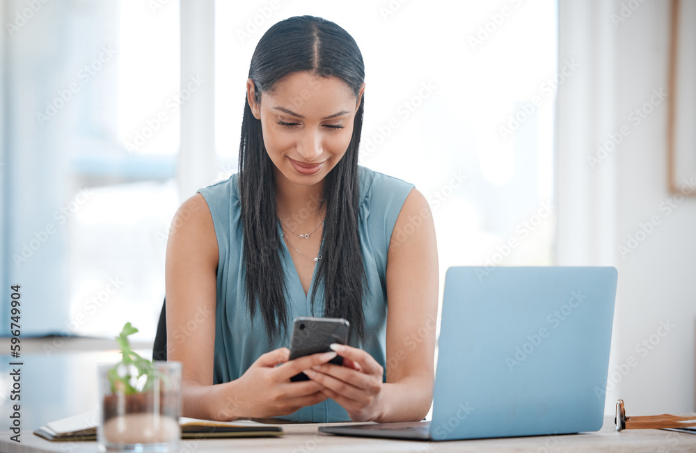 Aufkleber happy young mixed race businesswoman smiling while using a phone and working on a laptop sitting in 