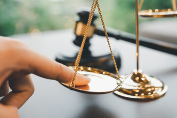 Tip the scales of justice concept as a the hand of a person illegally influencing the legal system...