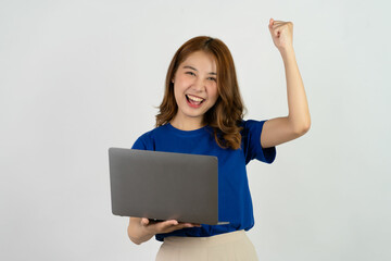 Happy smiling young woman of Asian ethnicity in blue shirt holding work on laptop computer isolated on white background studio portrait