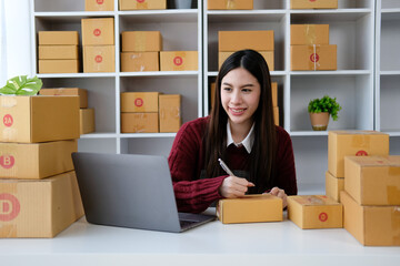 Startup small business entrepreneur of freelance Asian woman using a laptop with box Cheerful success online marketing packaging box and delivery SME idea concept