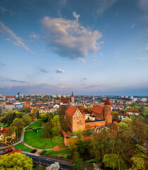 Olsztyn - park outside the castle, Łyna River, old town, castle, Evangelical church, high gate and co-cathedral basilica from a bird's eye view. spring light after sunset.