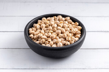 Chick pea uncooked beens. Studio shoot on light wooden background. 45 degrees shoot.