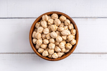 Chick pea uncooked beens. Studio shoot isolated on light wooden background. Up view shoot.