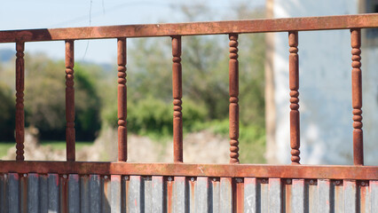 Barrotes oxidados en puerta rústica de granja