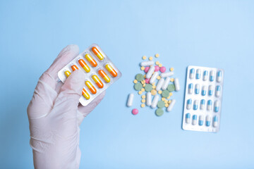Gloved hand with colorful pills. Healthcare and medicine concept flat lay