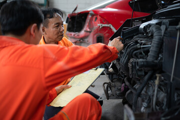 Fototapeta na wymiar Both of auto mechanics are inspecting the engine of a customer's car being brought in for repair at a garage.