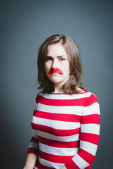 Young woman wearing mask against a grey background in studio. Young woman wearing mask against a grey background in studio.