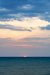 Sunset on the sea in the clouds with sun rays