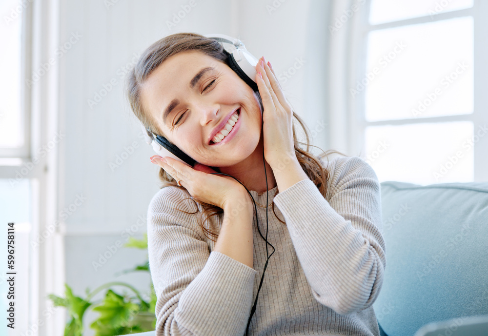 Canvas Prints She loves this song. Cropped shot of an attractive young woman listening to music while relaxing on the sofa at home.